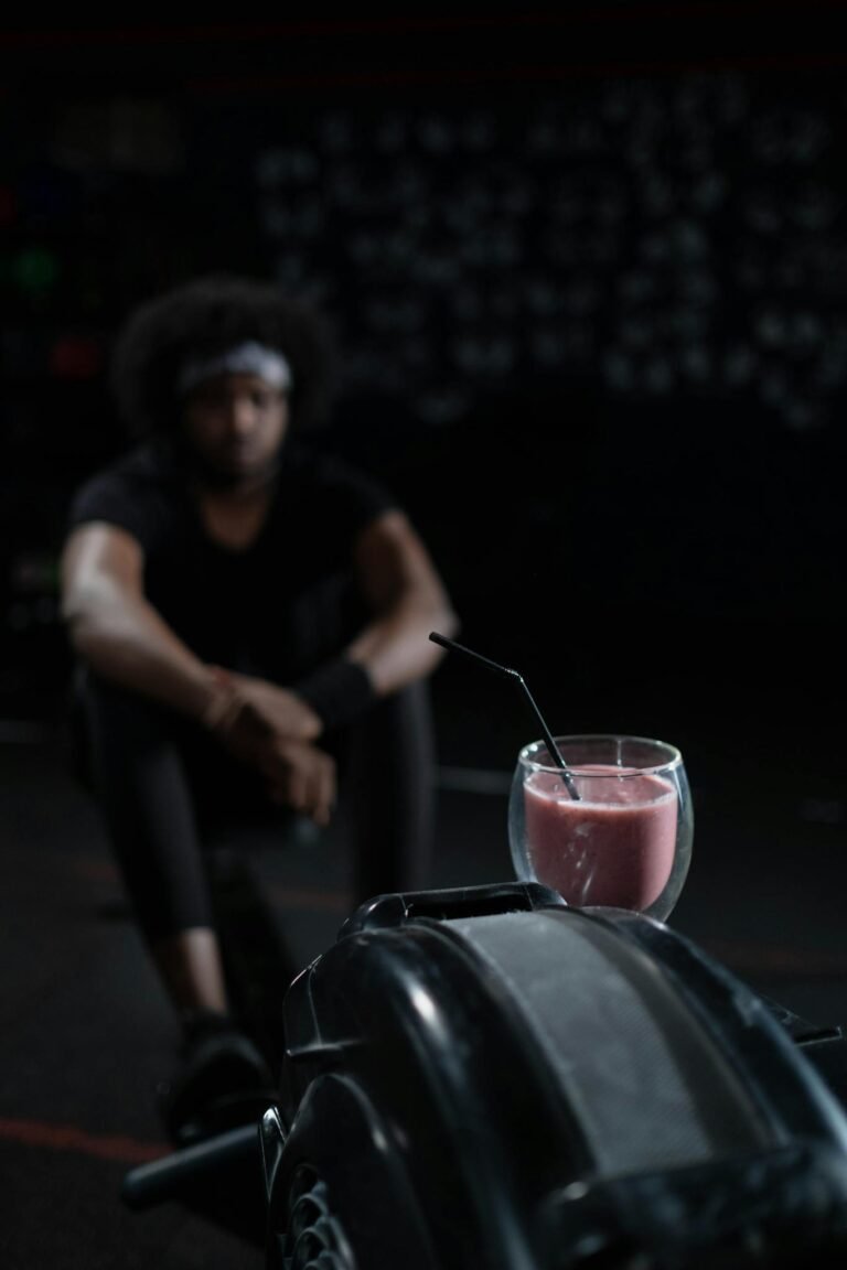 Strawberry smoothie with drinking straw in gym setting, perfect post-workout refreshment.